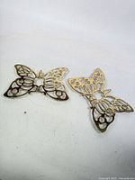 Two brass butterfly trivets overview