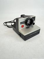 Front three-quarter view showing lens, Pronto! B badge, film slot