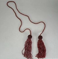 Full view of red glass beaded necklace with twin tassels