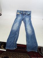 Full view of front of jeans laid flat