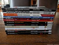 13 trade paperbacks stacked, spines visible with volume titles