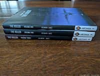 Spine view of all three hardcovers showing titles, volume numbers, authors and publisher logo