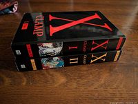 Spines of both X omnibus volumes I and II showing title, publisher logo, and volume numbers