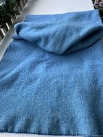 Full folded sea-blue wool blanket on table