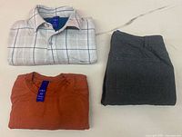 Overview of folded shirt, T-shirt, and trousers