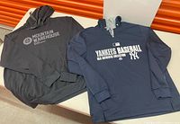 Two men’s hooded tops laid flat on table