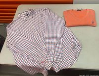 Shirt and sweater laid flat on table