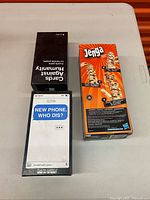 Three boxed games laid on table: Jenga, Cards Against Humanity, New Phone Who Dis?