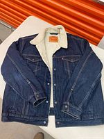 Front view of dark wash denim Sherpa Trucker Jacket with white sherpa lining