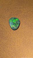 Triangular cabochon opal showing green flash