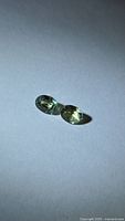 Pair of oval faceted sapphires on neutral background