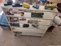 Full view of bookcase with vehicles on each shelf