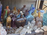 Front view of assorted vintage bottles on shelving