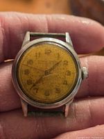 Front view showing Ernest Borel dial, numerals, hands, strap
