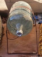 Glass jug resting horizontally in metal stand