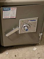 Front view of gray Sentry safe showing combination dial and handle