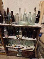 Full view of bookcase with bottles, books, coins