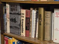 Shelf section showing war book spines including The U.S. Navy in World War II, Armageddon, Wake Island Command and others