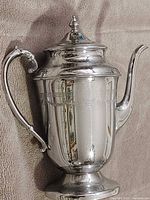 Full view of teapot showing shape, handle, spout, lid, foot