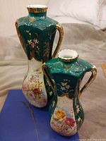 Both Royal Stafford vases showing height difference and decoration