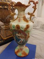 Full view of vase front showing figural scene and pedestal base