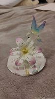 Full view of glass hummingbird and lily figurine on mirrored base