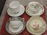 Four Paragon teacup and saucer sets displayed together