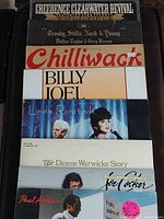 Stack of eight vinyl LPs showing album spines and partial covers