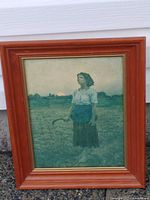 Full view of framed print standing against wall