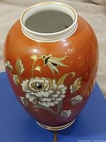 Front view of porcelain vase showing floral gold and white design
