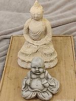 Both Buddha sculptures on wooden surface