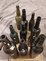 Group of 10 dark glass bottles on tray