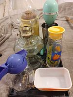 Group shot of oil lamp, mixer head with cup, two juice jugs and Pyrex dish