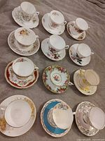 All twelve teacup and saucer sets laid out