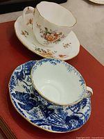 Both teacup and saucer sets displayed together