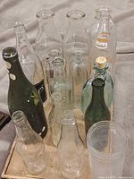 Overview of all fifteen vintage and antique glass bottles and jars arranged on wooden tray