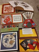 Overall view showing all boxed items: masks, calligraphy set, paper-cuts, fan, figurines, porcelain egg