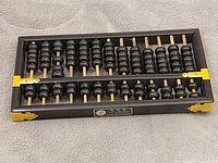 Top view of entire abacus showing frame, beads, and yellow corner brackets