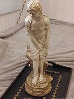 Full view of standing female chalkware statue on plinth