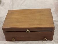 Closed hardwood jewelry box showing exterior finish and latches