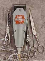 Front view of Pace clipper and three scissors on towel