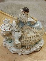 Full view of porcelain figurine showing woman, poodle and tea table