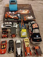 Group shot of entire lot showing tow truck, model kit box, plush car and assorted diecast vehicles