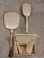 mirror, brush, open box with manicure tools and shoehorn