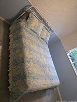 Full view of made-up double bed showing headboard, mattress and bedding