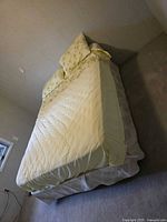 Side view of full-size bed showing mattress, box spring, metal frame and bedding