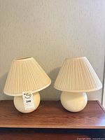 Both lamps unlit on wood surface showing shape and shade detail