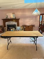 Top view of folding table fully opened, metal legs visible