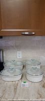 All four casserole dishes with lids grouped on countertop
