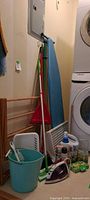 Group view of iron, ironing board, dustpan, mop, bucket, basket, drying rack, detergent, dryer sheets and scented oil refills